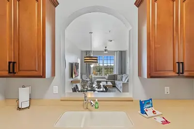 a kitchen with an archway over a kitchen sink at Apartamento 3Q Vista Cay c/ Varanda e Jogos in Orlando