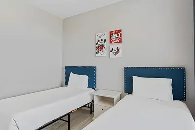 two beds in a room with white and blue at Apartamento 3Q Vista Cay c/ Varanda e Jogos in Orlando