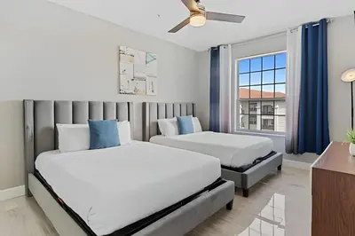 a bedroom with two beds and a window at Apartamento 3Q Vista Cay c/ Varanda e Jogos in Orlando