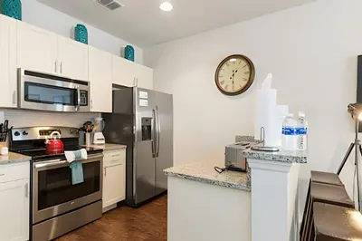 a kitchen with a refrigerator and a clock on the wall at Townhouse 3Q Perto da Disney c/ Mickey Room in Kissimmee