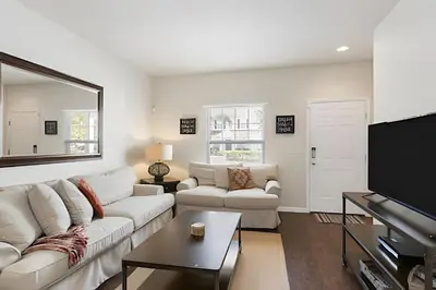 a living room with a white couch and a flat screen tv at Townhouse 3Q Perto da Disney c/ Mickey Room in Kissimmee
