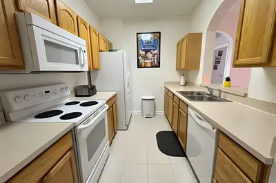 a kitchen with white appliances and wooden cabinets at Condo 3Q Windsor Hills — Perto da Disney in Orlando