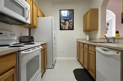 a kitchen with white appliances and wooden cabinets at Condo 3Q Windsor Hills — Perto da Disney in Orlando