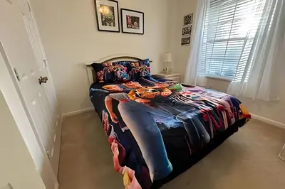 a bedroom with a bed with a colorful blanket on it at Condo 3Q Windsor Hills — Perto da Disney in Orlando