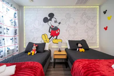 a bedroom with two beds and a mickey mouse mural at Beautiful 2 bedrooms with Hot tube in Kissimmee