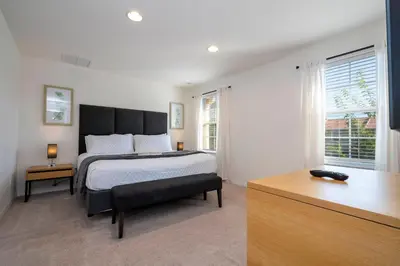 a bedroom with a large bed and a desk at Cozy 2 bedrooms with Hot tube in Kissimmee