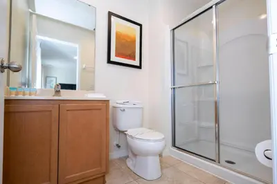 a bathroom with a toilet and a glass shower at Cozy 2 bedrooms with Hot tube in Kissimmee