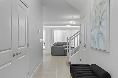 a white hallway with a black couch and a living room at Mansão 9Q Paradiso Grande. Piscina, Sala de Jogos in Orlando