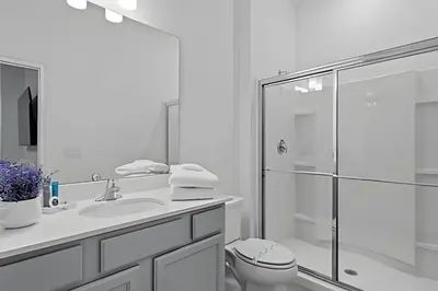 a white bathroom with a toilet and a shower at Mansão 9Q Paradiso Grande. Piscina, Sala de Jogos in Orlando