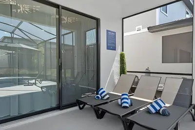 a room with tables and chairs in front of a building at Mansão 9Q Paradiso Grande. Piscina, Sala de Jogos in Orlando