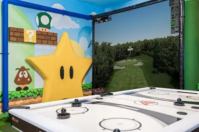 a stage with a white sink in front of a video game screen at 10min to Disney, Luxury 6BR Themed Villa with Private Pool,Spa and Game Room in Orlando