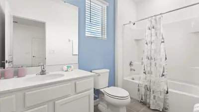 a white bathroom with a toilet and a sink at Upstay Veranda Palms Villa Pool Hot Tub & Games in Kissimmee
