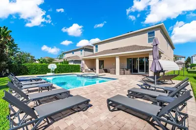 a villa with a swimming pool and lounge chairs at Fun-Filled Getaway With Private Pool, Theme Rooms & Game Room And Waterpark Access Near Disney At Encore Resorts Reunion - 7604Mc in Orlando