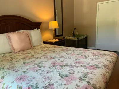 a bedroom with a large bed with a floral blanket at Ortona's Best Kept Secret Three-Two Spacious Home in Orlando