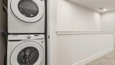 a washer and dryer next to a refrigerator at Stunning Townhome with Private Pool & Games Room in Orlando