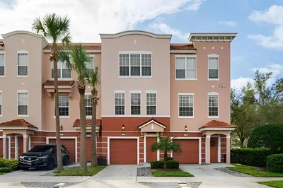 a large apartment building with a car parked in the driveway at Casa 3Q Vista Cay – Perto da Universal & Centro in Orlando