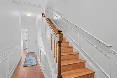 a staircase in a home with white walls and wood floors at Casa 3Q Vista Cay – Perto da Universal & Centro in Orlando