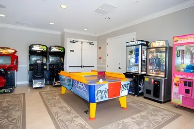 a room with arcade games and a table in the middle at Casa 3Q Vista Cay – Perto da Universal & Centro in Orlando