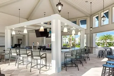 an outdoor patio with a bar and chairs at Villa Sanches 4Q c/ Piscina – Storey Lake Resort in Kissimmee