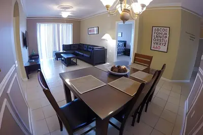 a dining room and living room with a table and chairs at Condo 3Q Windsor Hills — Perto da Disney in Orlando