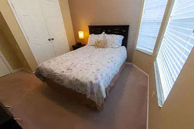a bedroom with a bed with a white comforter and a window at Condo 3Q Windsor Hills — Perto da Disney in Orlando