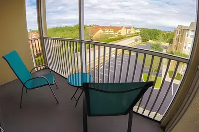 a balcony with two chairs and a view of a street at Condo 3Q Windsor Hills — Perto da Disney in Orlando