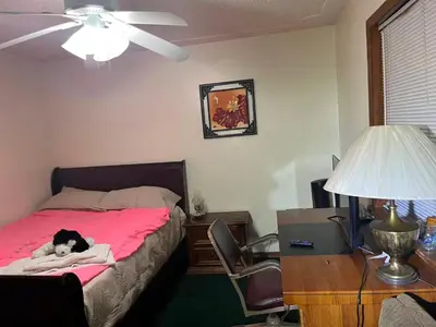 a dog laying on a bed in a bedroom at Red brick house in Kissimmee