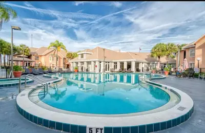 a large swimming pool in the courtyard of a apartment building at Mickey's Hideaway Condo Near Disney in Orlando