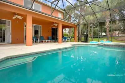 a swimming pool in front of a house at Family Retreat near Disney with Private Pool in Kissimmee