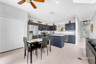 a kitchen and dining room with a table and chairs at Family Retreat near Disney with Private Pool in Kissimmee