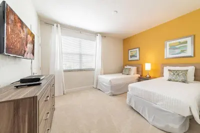 a bedroom with two beds and a desk and a window at Casa 3Q Serenity c/ Piscina – Perto da Disney in Orlando