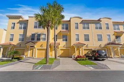 a large yellow building with a car parked in front of it at Amplo Townhouse 3 Quartos no Vista Cay Resort in Orlando