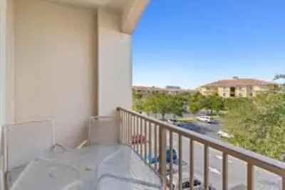 a balcony with a table and a view of a street at Condo 3Q Vista Cay c/ Varanda e Piscina Resort in Orlando