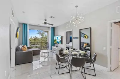 a dining room and living room with a table and chairs at Condo 3Q Vista Cay c/ Varanda e Piscina Resort in Orlando