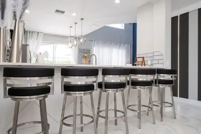 a kitchen with black and white bar stools at Enchanting 6BR, Themed Rooms, Game Room and Resort in Kissimmee