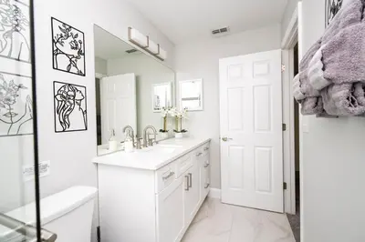 a white bathroom with a sink and a mirror at Enchanting 6BR, Themed Rooms, Game Room and Resort in Kissimmee