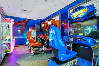 a childs room with a video game arcade at Spacious Fun Retreat With Private Pool And Game Room Near Disney And Waterpark & Resort Access At Encore Resorts Reunion - 7659Wi in Orlando