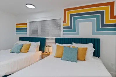 two beds sitting next to each other in a bedroom at Kissimmee Retreat with Jacuzzi and Games in Kissimmee