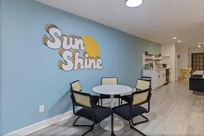 a table and chairs in a room with a sign on the wall at Kissimmee Retreat with Jacuzzi and Games in Kissimmee