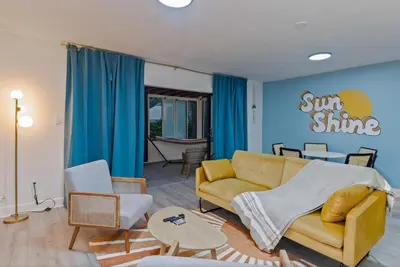 a living room with a yellow couch and blue walls at Kissimmee Retreat with Jacuzzi and Games in Kissimmee