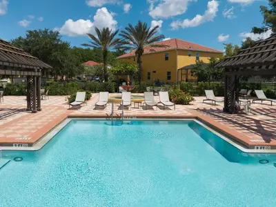 a swimming pool with lounge chairs and a house at Refúgio c/ Vista do Lago e Piscina – Perto Disney in Kissimmee
