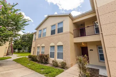 an apartment building with a sidewalk in front of it at Family-Friendly Apartment Near Disney & Universal in Kissimmee