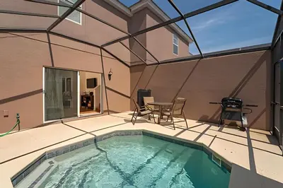 a swimming pool on a patio with a table and chairs at Conforto e Diversão no Bella Vida – 3Q+ Piscina in Kissimmee