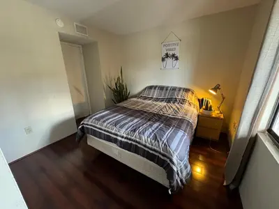 a bedroom with a bed with a striped comforter at Residence near trails, shopping in Orlando