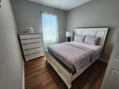 a bedroom with a white bed and a dresser at Orlando Luxury Home in Orlando