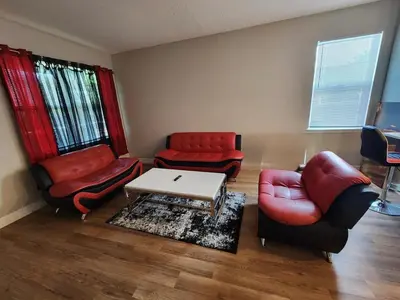 a living room with red chairs and a table at Orlando Luxury Home in Orlando