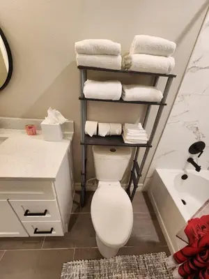a bathroom with a toilet and a sink and towels at Orlando Luxury Home in Orlando