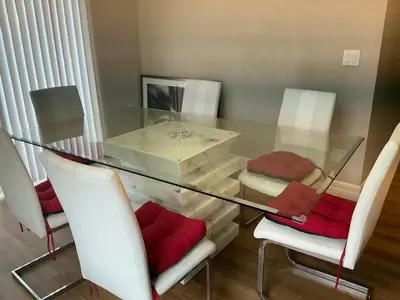 a glass table with white chairs and red cushions at Orlando Luxury Home in Orlando