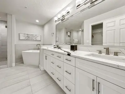 a white bathroom with two sinks and a bath tub at Family-Friendly 3-Bedroom Condo for 6 and 5 min to Disney in Orlando