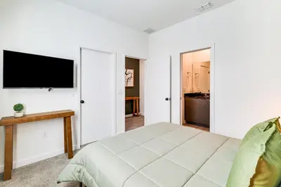 a bedroom with a bed and a flat screen tv at 4 Mi to Disney! Pet-Friendly Home with Pool Access in Kissimmee